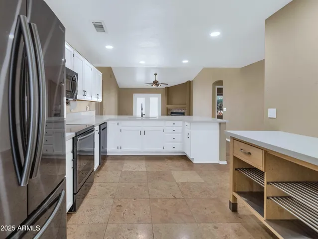 a large kitchen with a large counter top stainless steel appliances and cabinets
