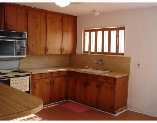 a kitchen with a sink window and cabinets