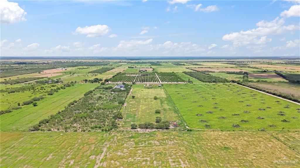 27870 North Western Road Mission, TX 78574 - Photo 5 of 8 Expansive agricultural land featuring a diverse landscape of cultivated fields, green pastures, and rows of established trees