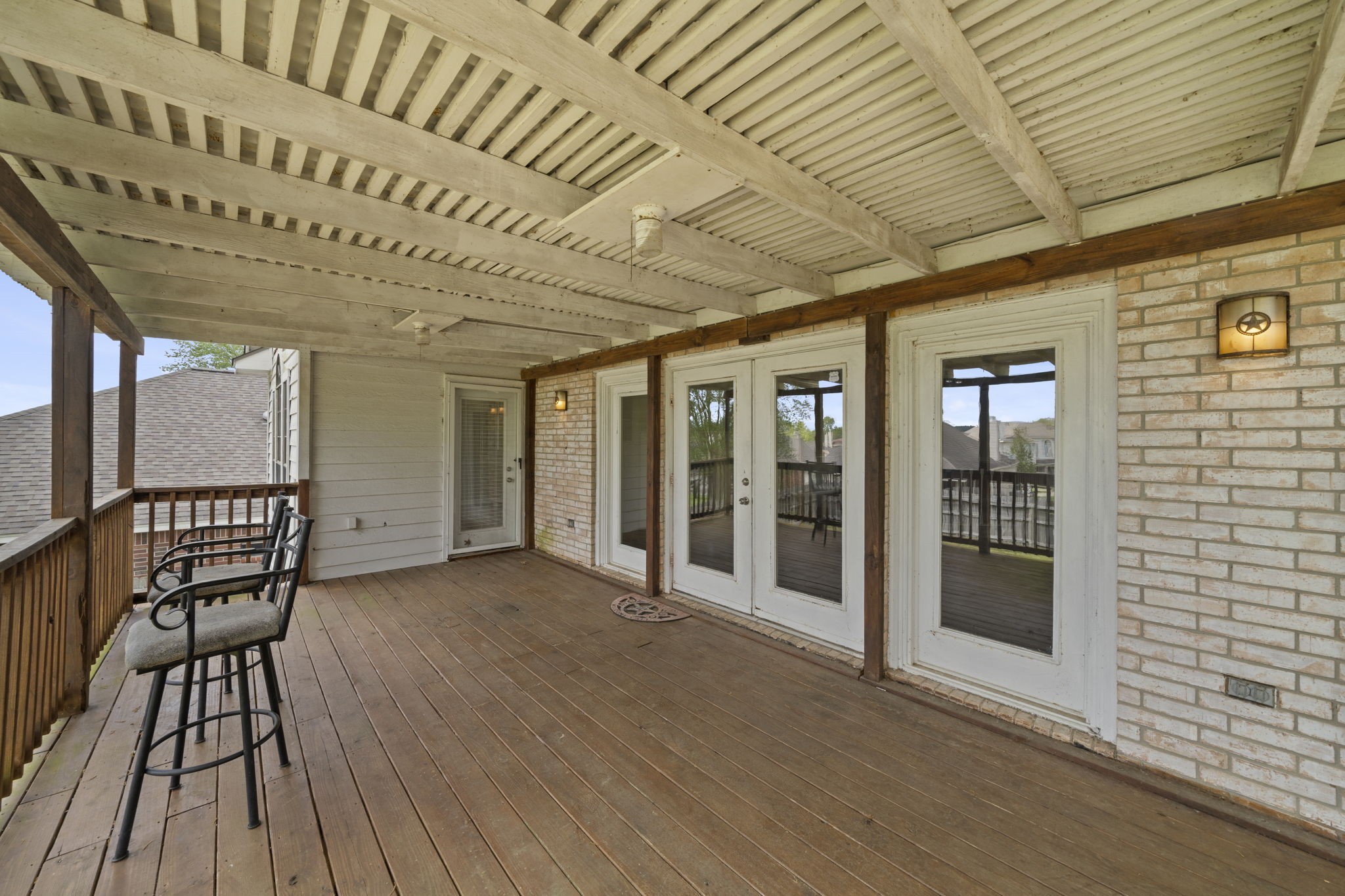 169 April Cove Montgomery, TX 77356 - Photo 27 of 39 Spacious covered balcony featuring wood decking, exposed beam ceiling, and plenty of room for seating—perfect for relaxing or entertaining.