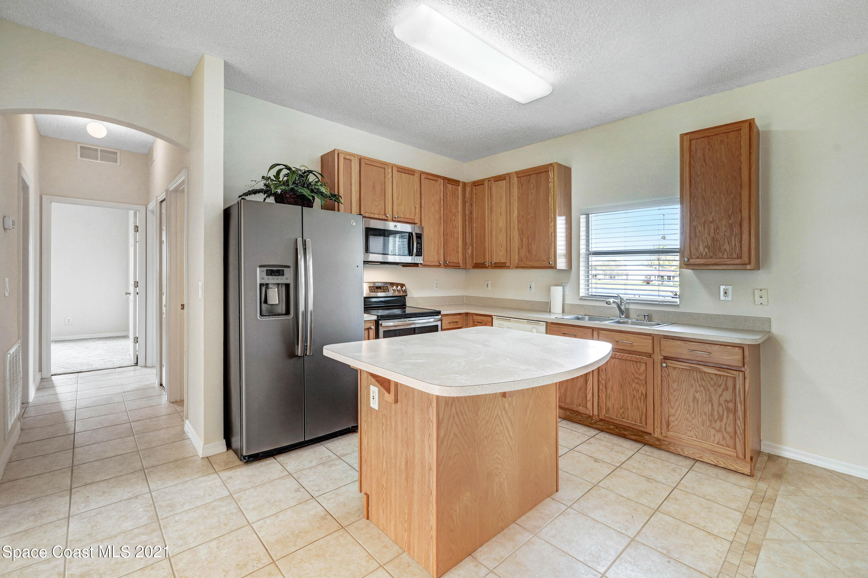 1475 Knoll Ridge Drive Melbourne, FL 32940 - Photo 17 of 39 a kitchen with stainless steel appliances granite countertop a sink stove and refrigerator