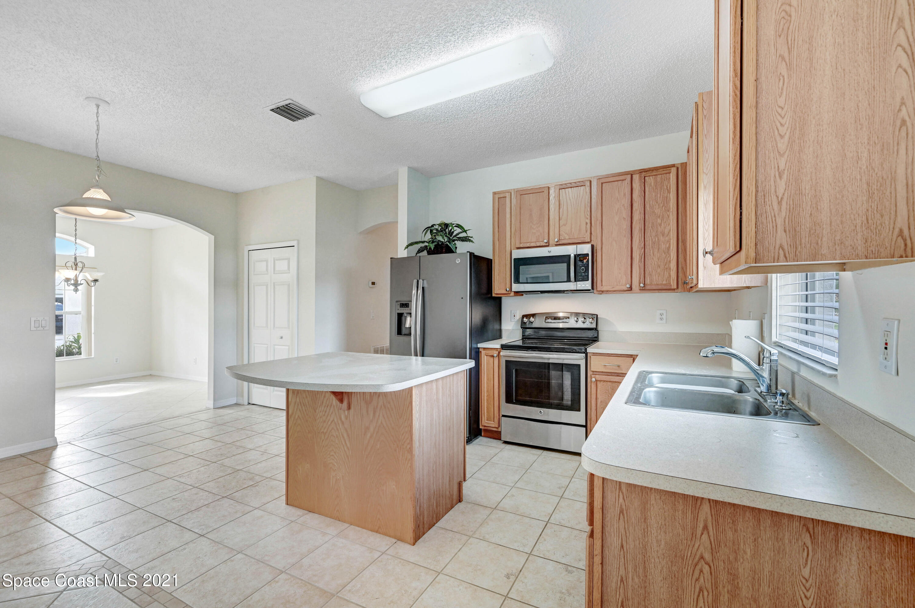 1475 Knoll Ridge Drive Melbourne, FL 32940 - Photo 18 of 39 a kitchen with a stove top oven sink and cabinets