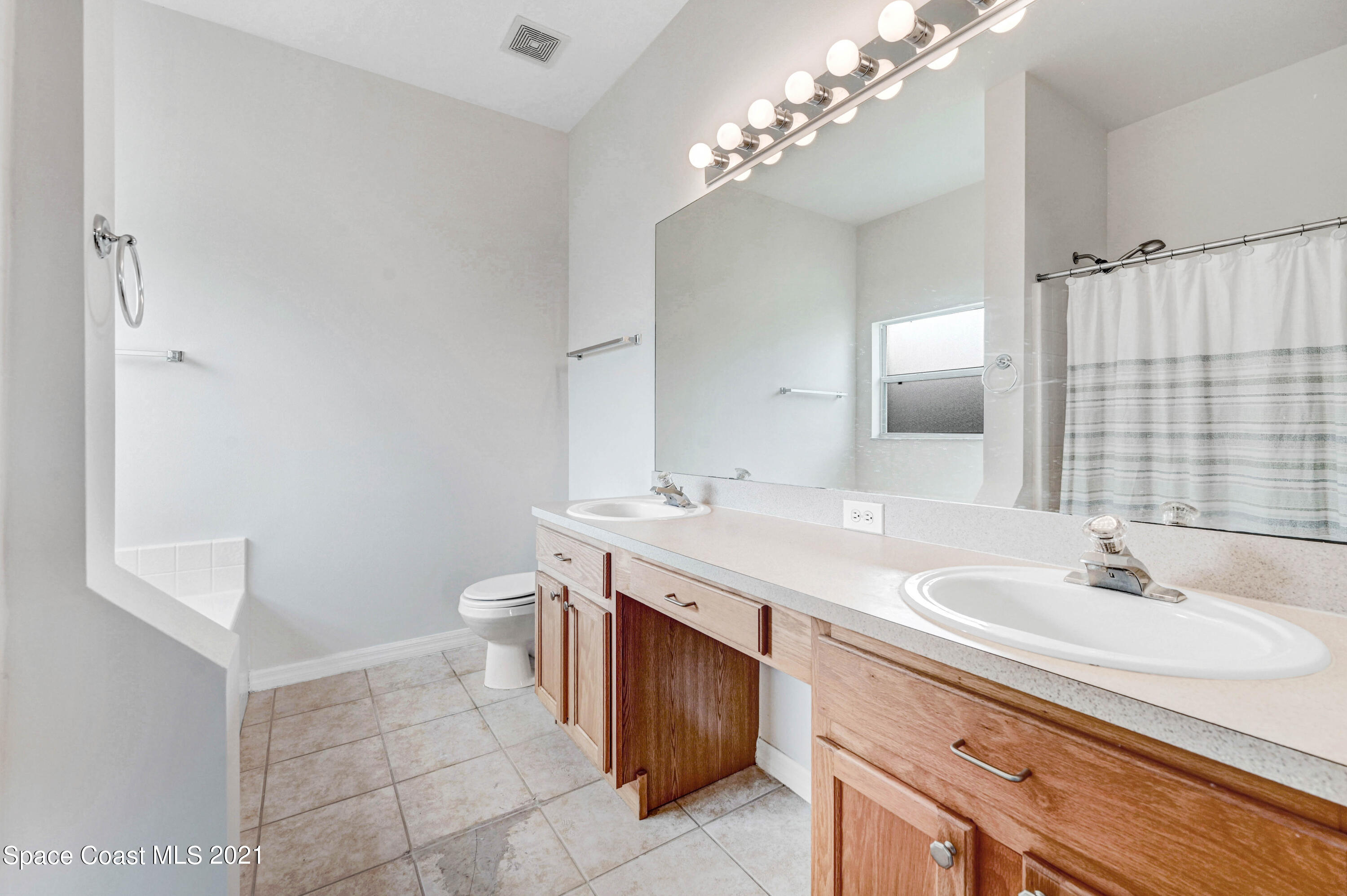 1475 Knoll Ridge Drive Melbourne, FL 32940 - Photo 25 of 39 a bathroom with a sink a toilet and a mirror