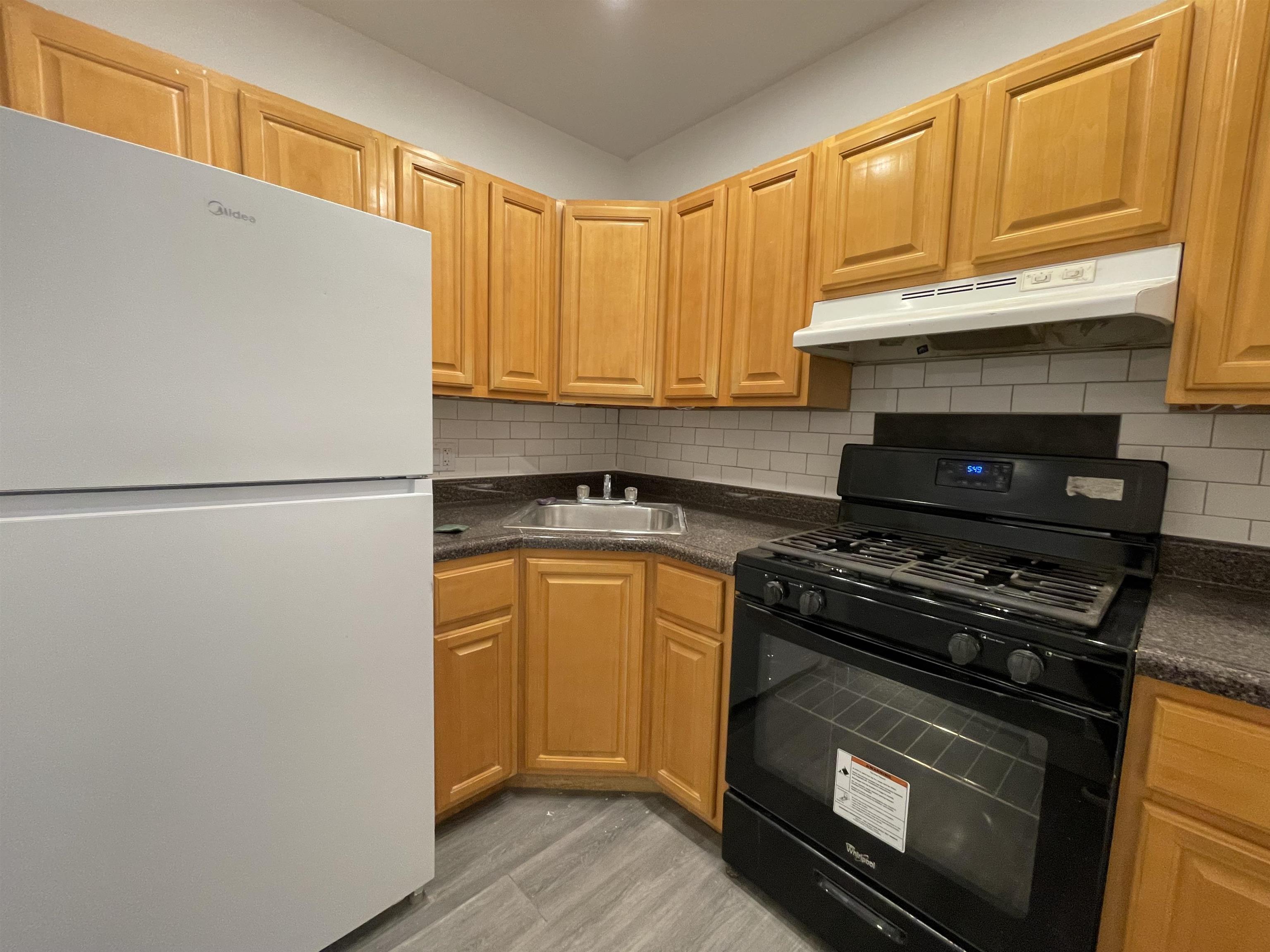 516 Paterson Plank Road, Unit 2R Jersey City, NJ 07307 - Photo 12 of 13 a kitchen with stainless steel appliances granite countertop a stove a refrigerator and a refrigerator