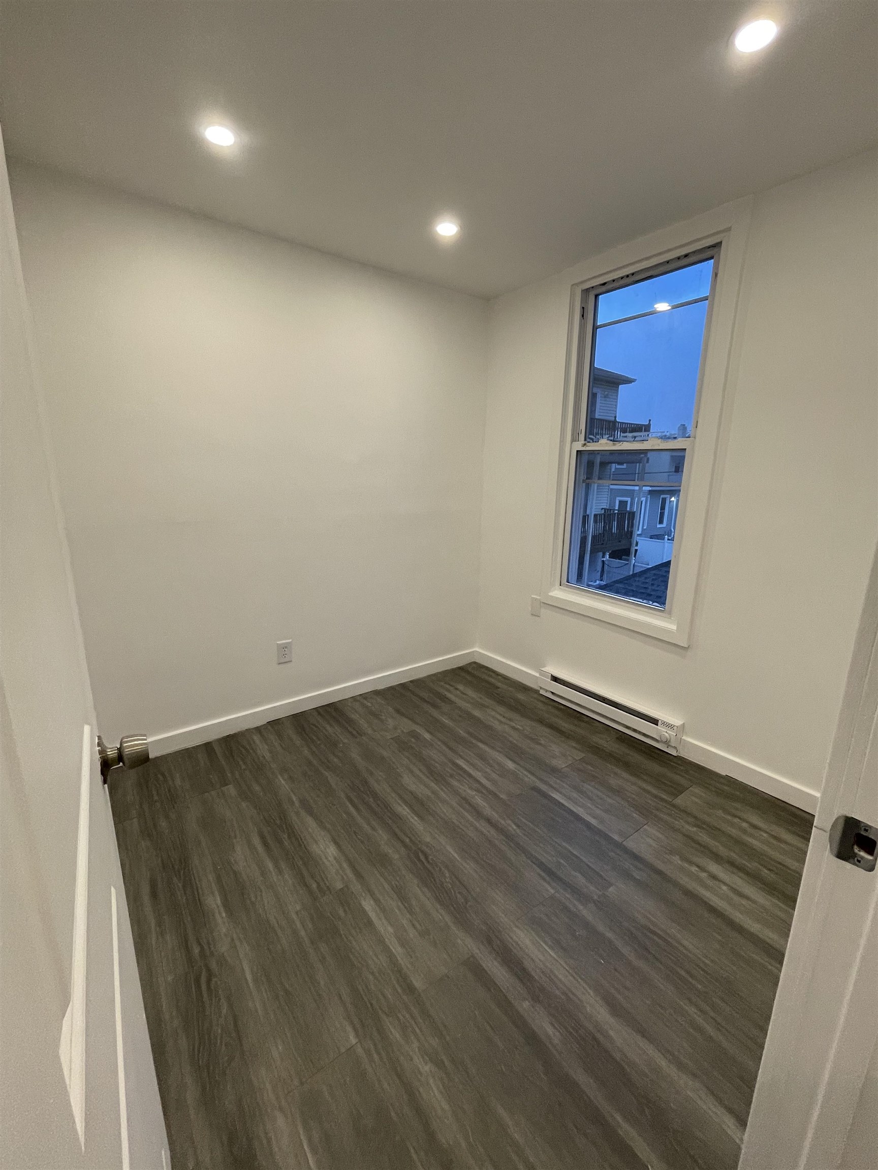 516 Paterson Plank Road, Unit 2R Jersey City, NJ 07307 - Photo 13 of 13 an empty room with wooden floor and windows