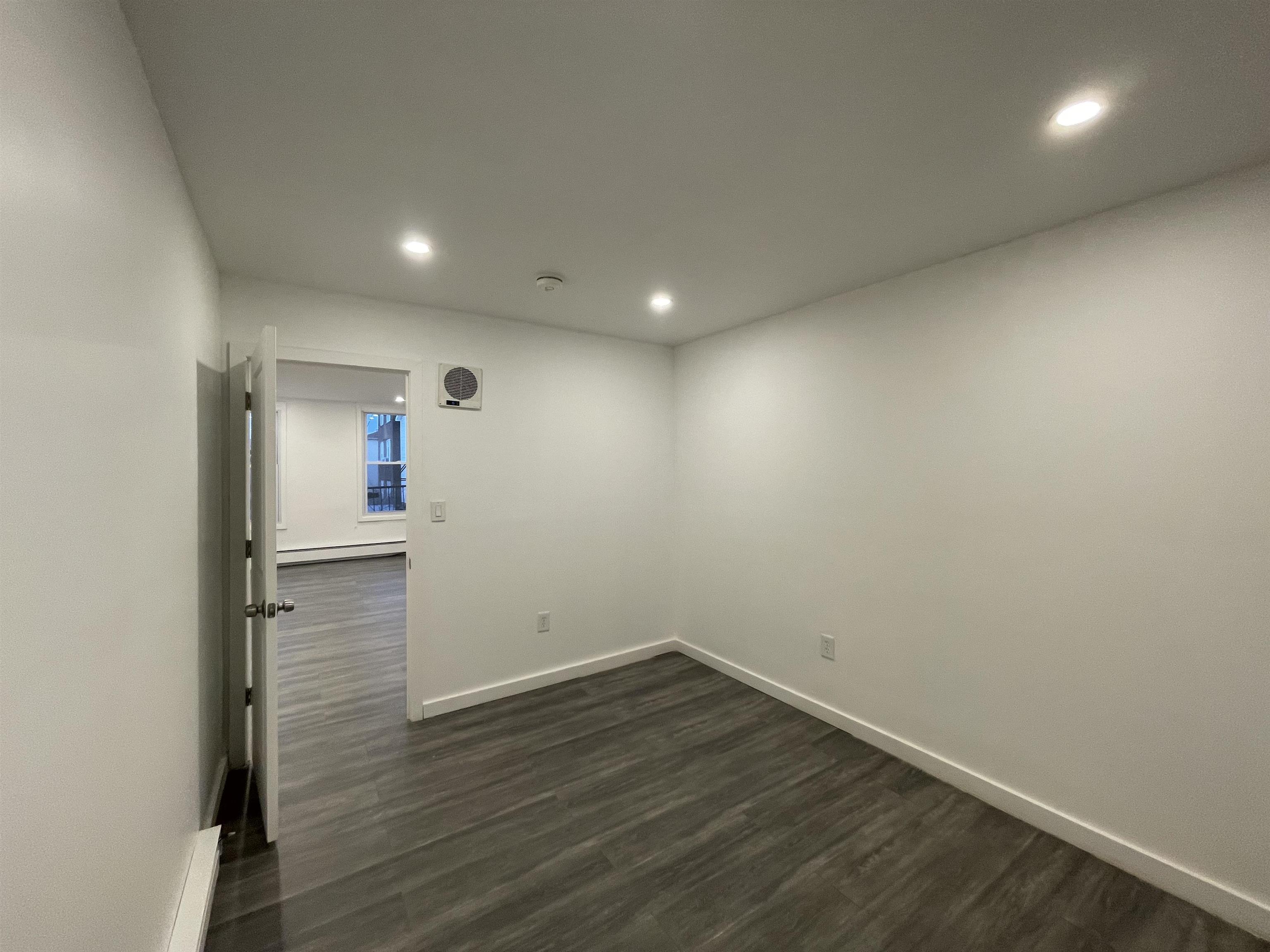 516 Paterson Plank Road, Unit 2R Jersey City, NJ 07307 - Photo 3 of 13 an empty room with wooden floor and entrance