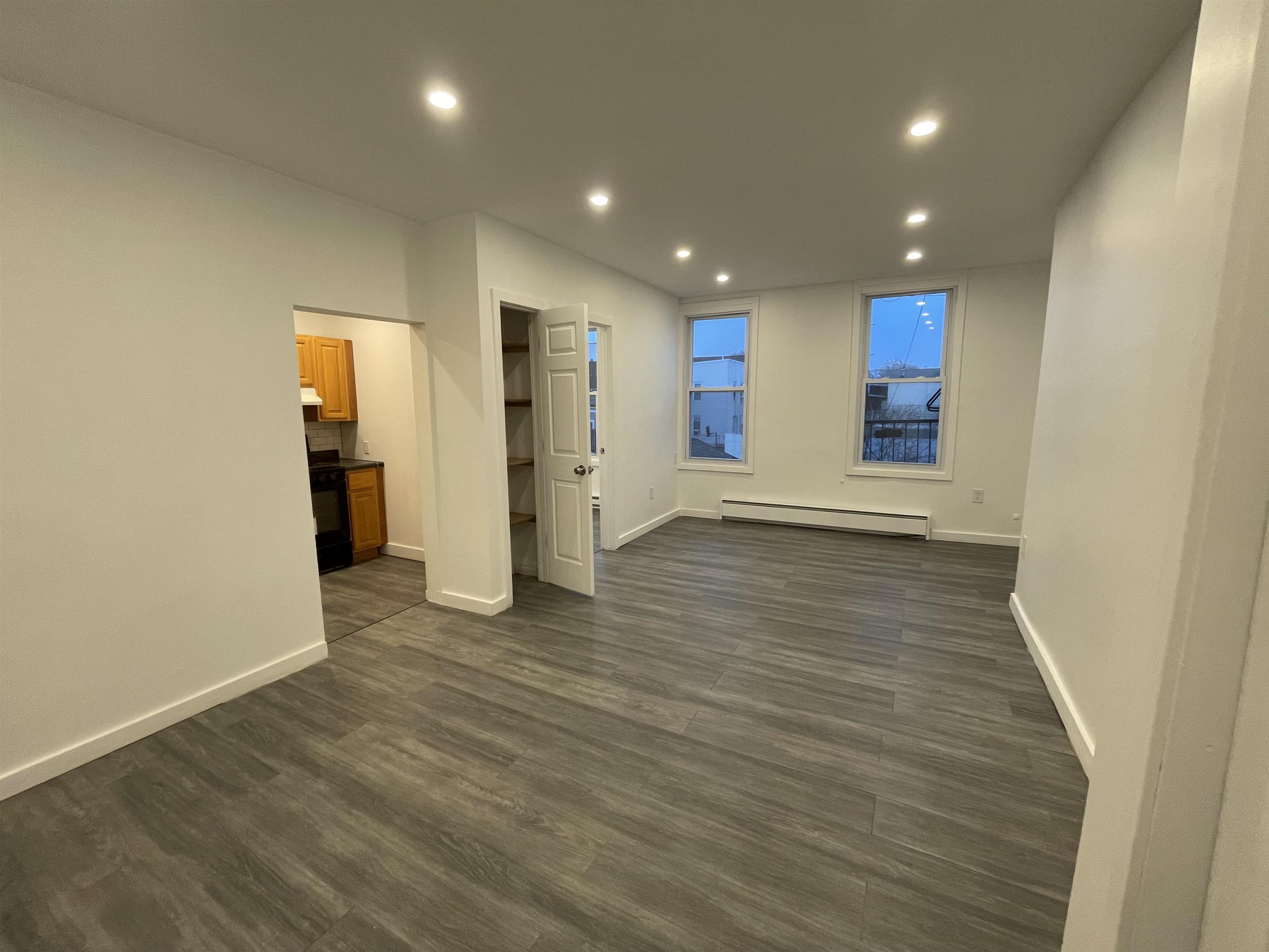 516 Paterson Plank Road, Unit 2R Jersey City, NJ 07307 - Photo 9 of 13 an empty room with wooden floor and windows