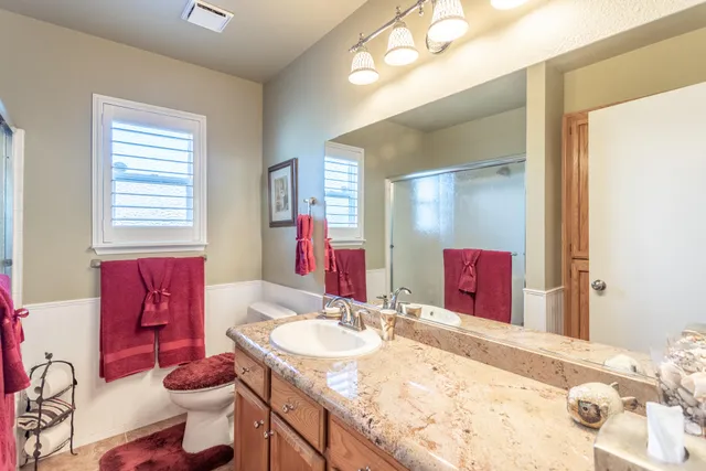 a bathroom with a granite countertop sink and a mirror