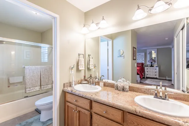 a bathroom with a granite countertop sink toilet and shower