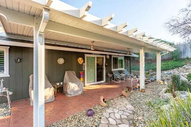 a view of a dinning table and chairs in patio of the house