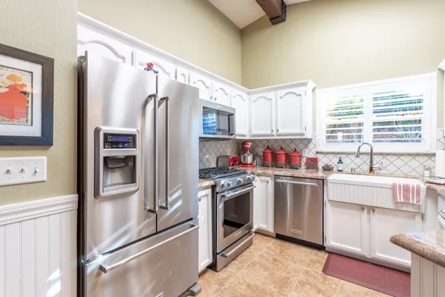 a kitchen with stainless steel appliances a refrigerator sink and microwave