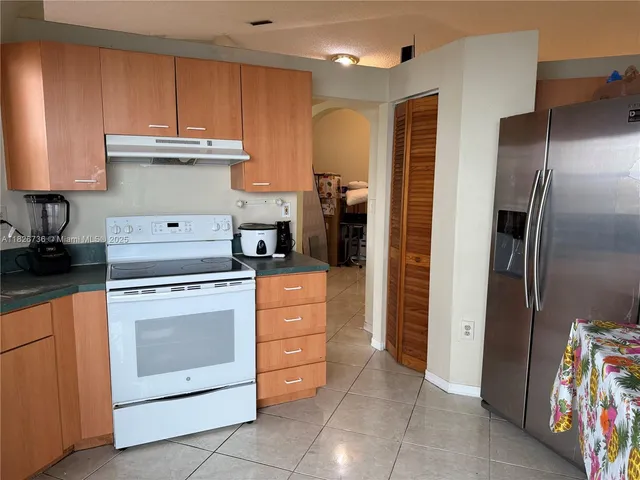 a kitchen with stainless steel appliances granite countertop a refrigerator and a stove