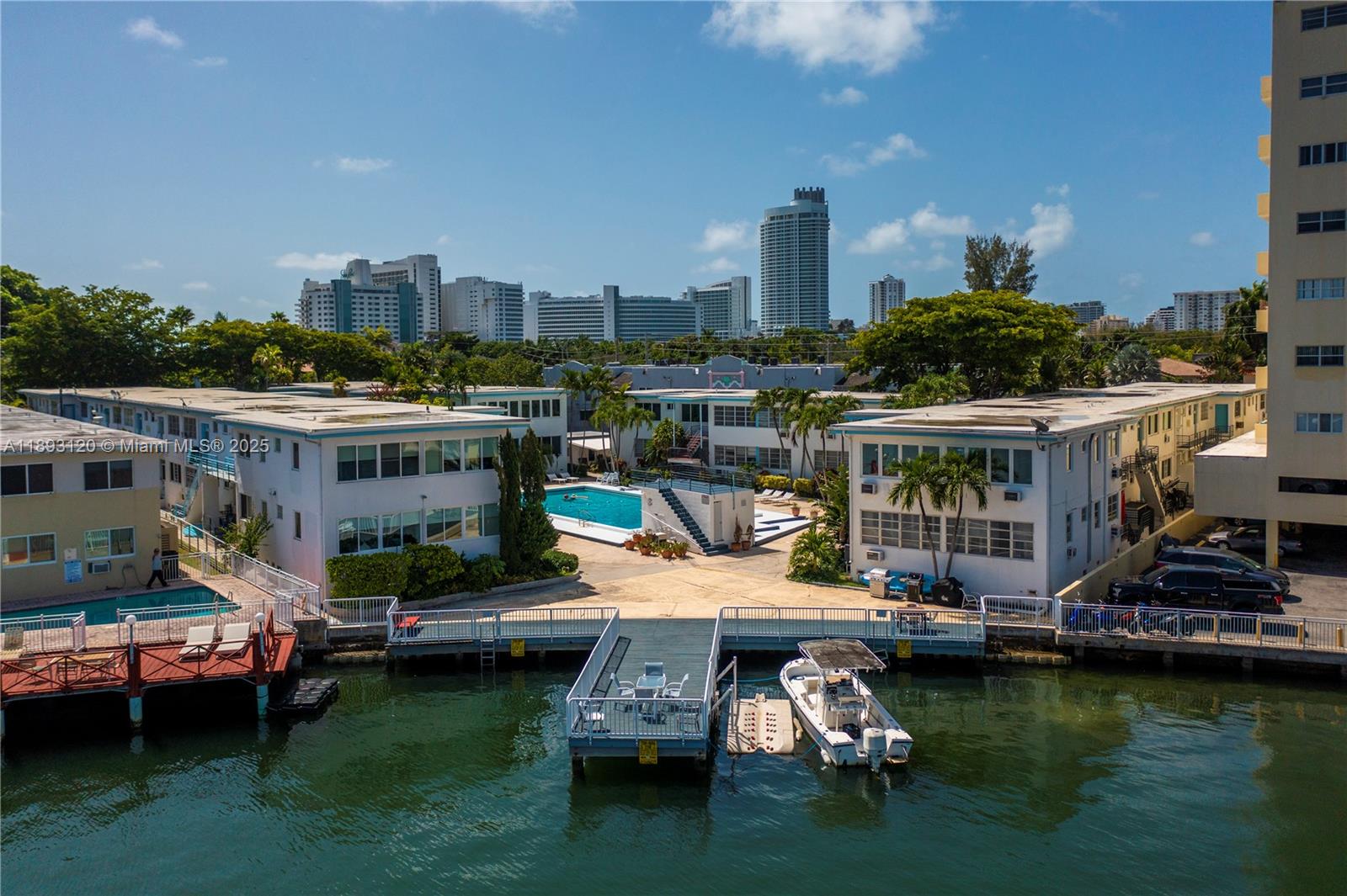 4720 Pine Tree Drive, Unit 2 Miami Beach, FL 33140 - Photo 22 of 23 a view of a lake with lawn chairs and a fire pit
