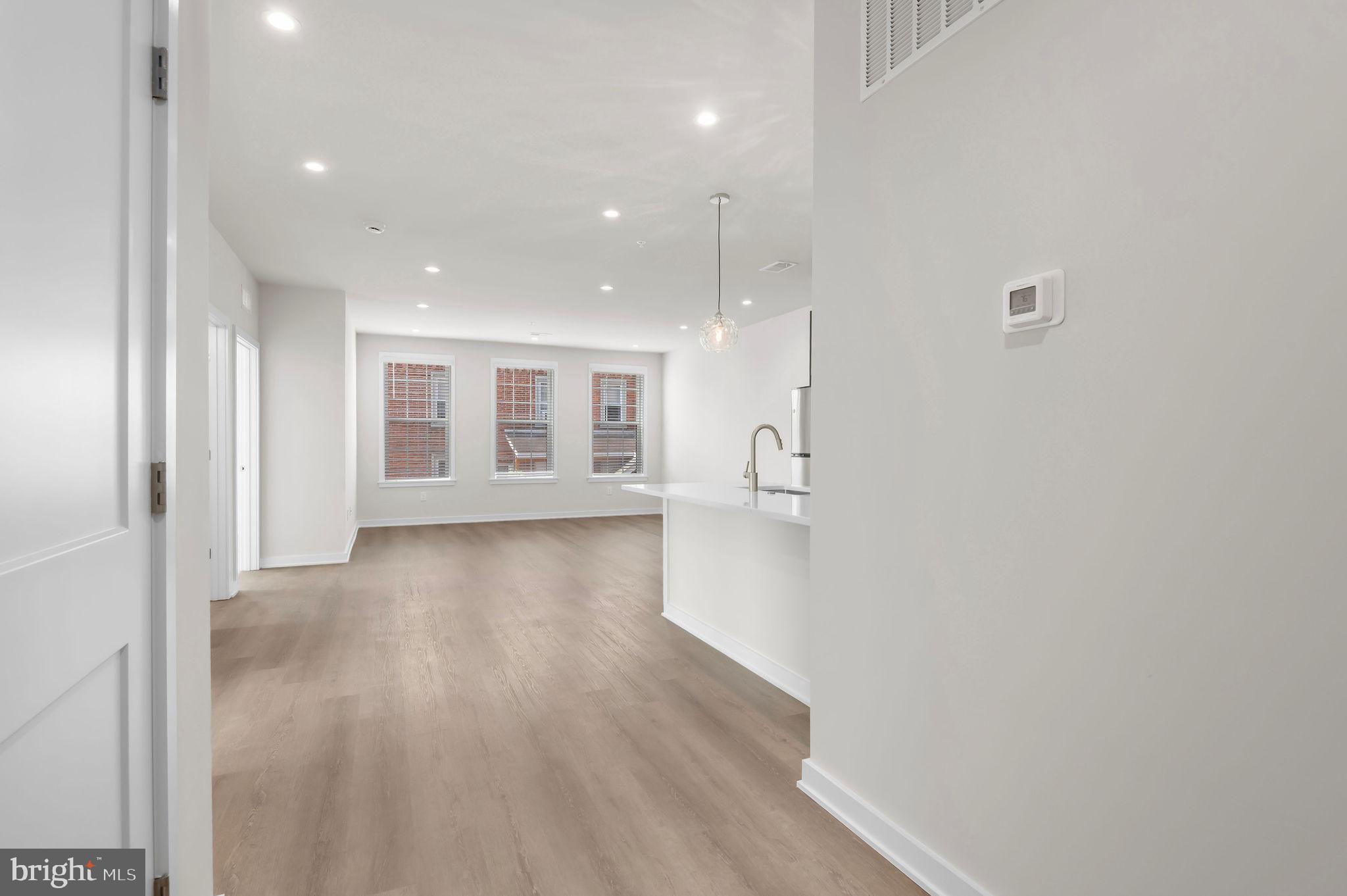a view of a big room with wooden floor and windows
