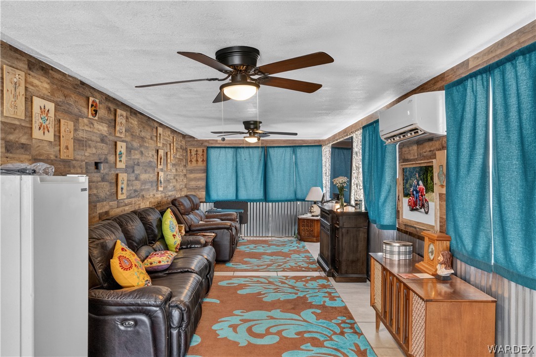 784 Pegasus Ranch Road Bullhead City, AZ 86429 - Photo 50 of 100 Spacious room featuring multiple ceiling fans, wood-finish accent walls, and corrugated metal wall accents