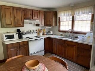236 Chappaquiddick Road Edgartown, MA 02539 - Photo 8 of 16 a kitchen with a sink cabinets appliances and a window