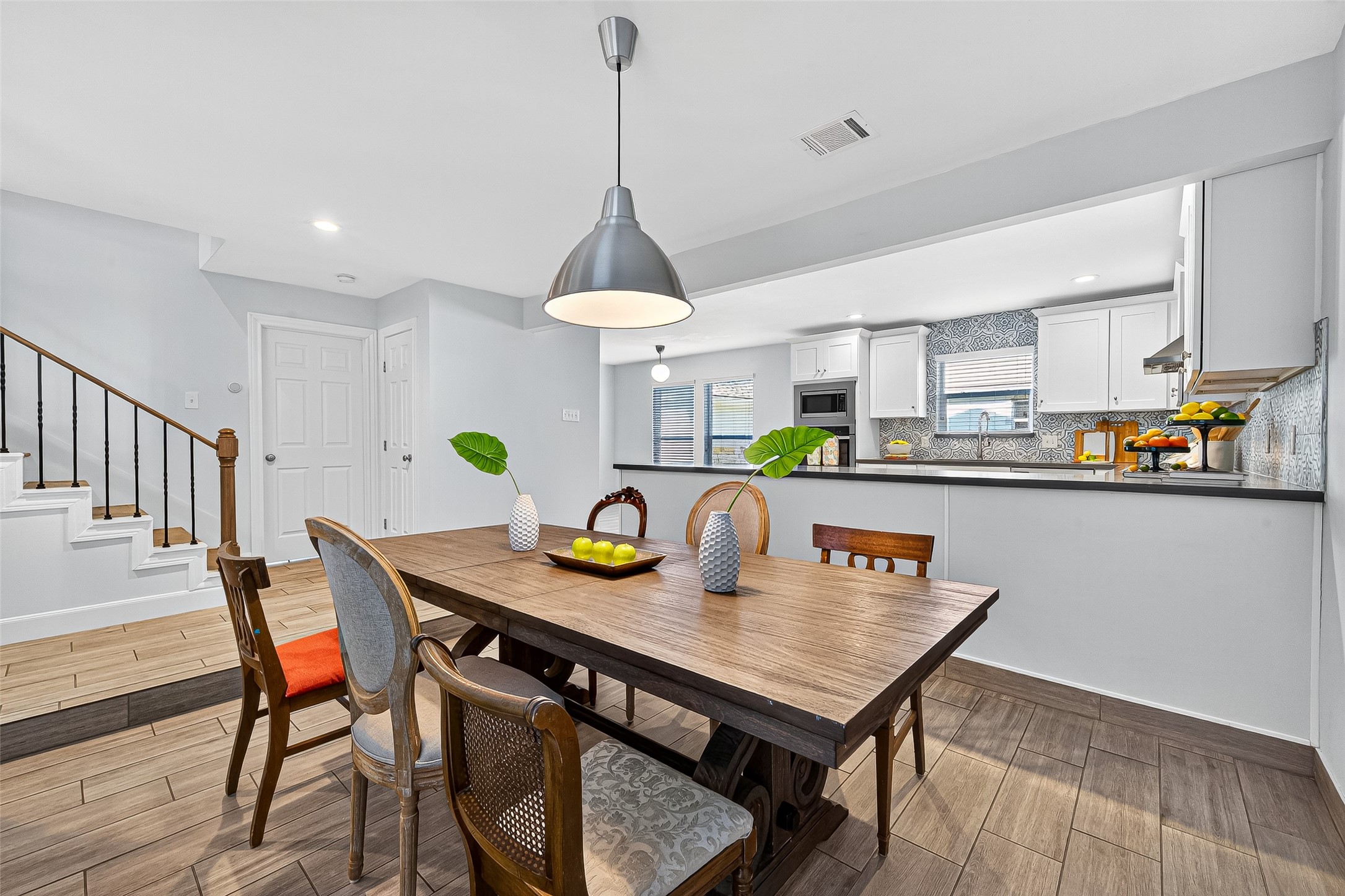818 Silvergate Drive Houston, TX 77079 - Photo 11 of 40 a view of a dining room and livingroom with furniture wooden floor a rug a painting and a chandelier