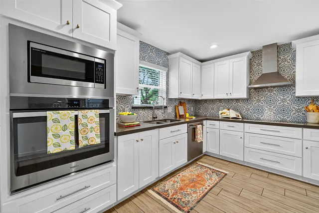 a kitchen with stainless steel appliances granite countertop a stove microwave and sink