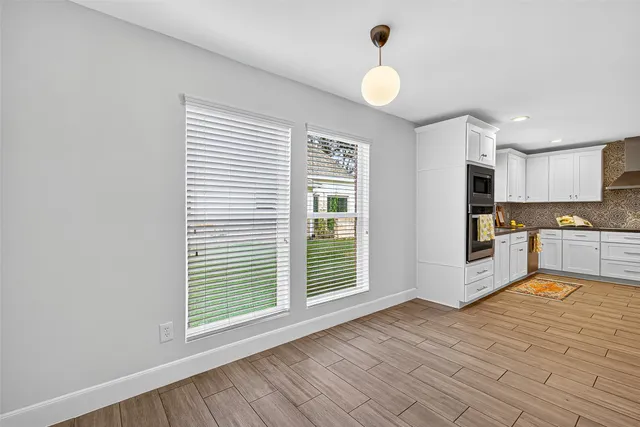 a large kitchen with cabinets and wooden floor