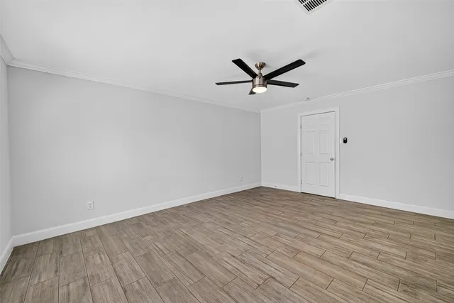 a view of a big room with wooden floor and a ceiling fan