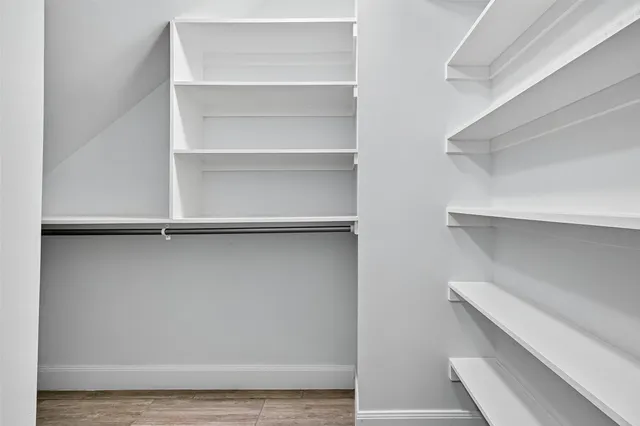 a view of walk in closet with empty racks