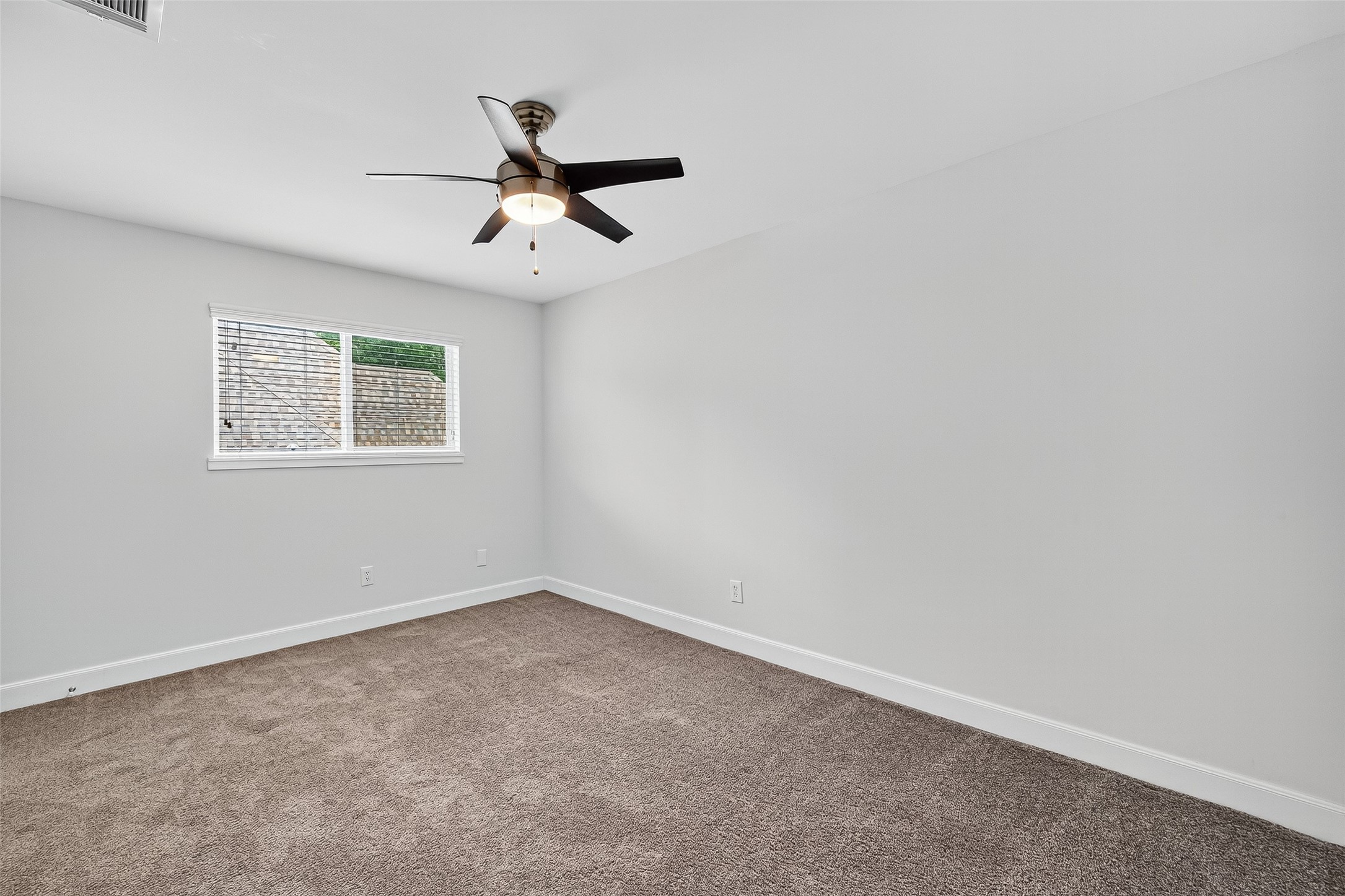 818 Silvergate Drive Houston, TX 77079 - Photo 31 of 40 an empty room with a window and a fan