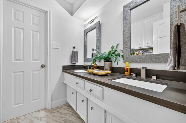 a bathroom with cabinets and mirror