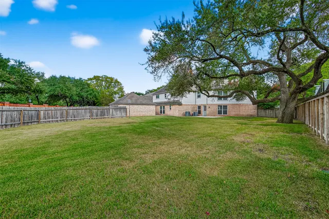 a view of house with backyard and tree