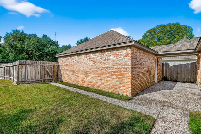 a view of a house with a small yard and wooden fence