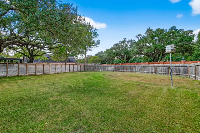 a view of a yard with wooden fence