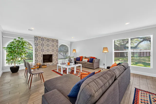 a living room with furniture a fireplace and a floor to ceiling window