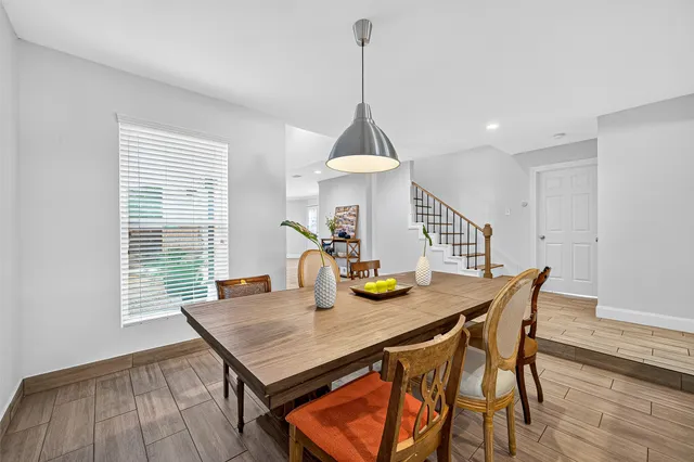 a view of a dining table and chairs in wooden floor