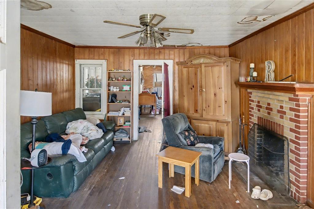 815 Northeast 145th Avenue Road Silver Springs, FL 34488 - Photo 31 of 42 a living room with furniture a fireplace and a chandelier