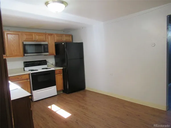 a kitchen with granite countertop a refrigerator and a stove top oven