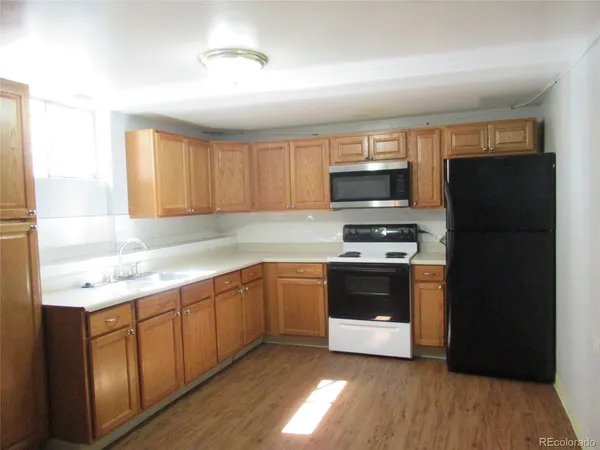 a kitchen with granite countertop a refrigerator and a stove top oven