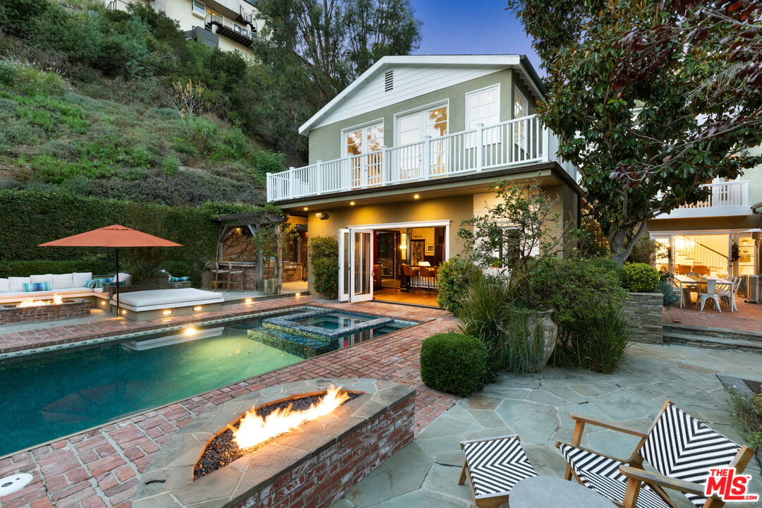 a front view of a house with swimming pool having outdoor seating