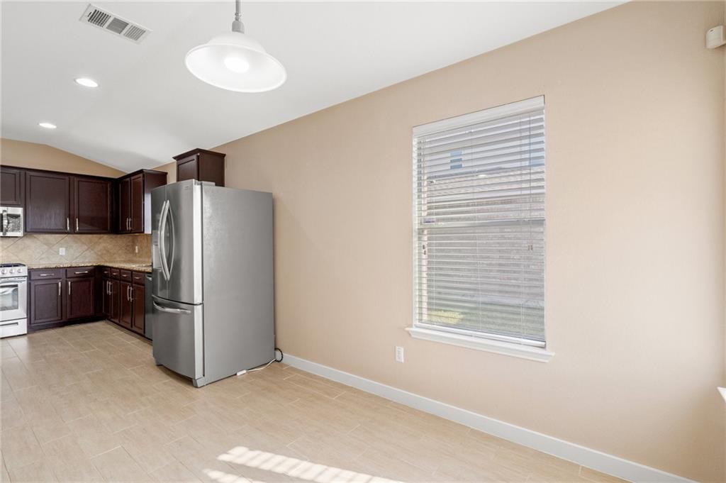 20224 Merlin Falcon Trail Pflugerville, TX 78660 - Photo 24 of 40 A well-equipped kitchen features a stainless steel refrigerator and ample cabinet space.