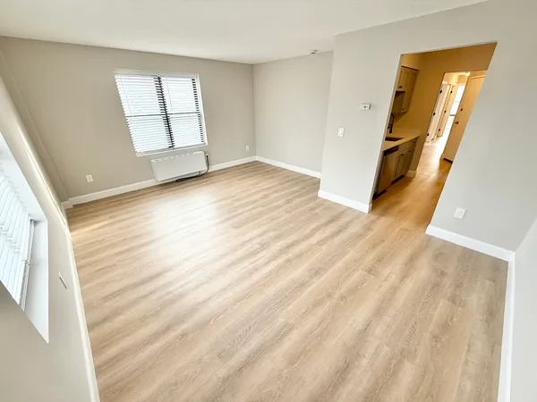 wooden floor in an empty room with a window