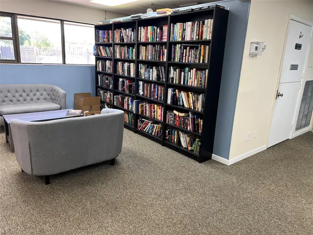 a living room with furniture and a book shelf