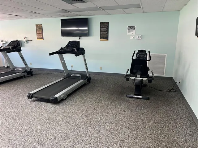 a room with gym equipment and a flat screen tv