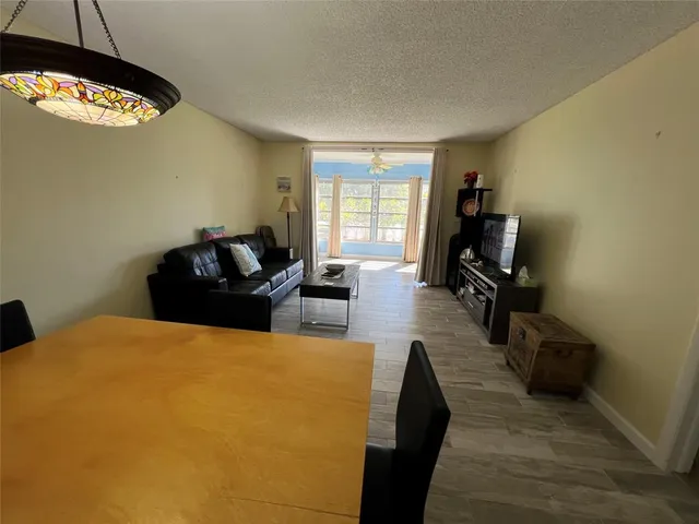 a living room with furniture a flat screen tv and a window
