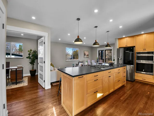 a kitchen with stainless steel appliances granite countertop a stove and a wooden floors