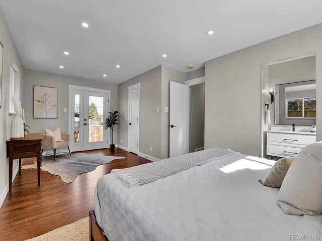 a bedroom with a large bed and wooden floor