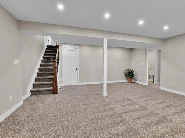 an empty room with a staircase and white walls