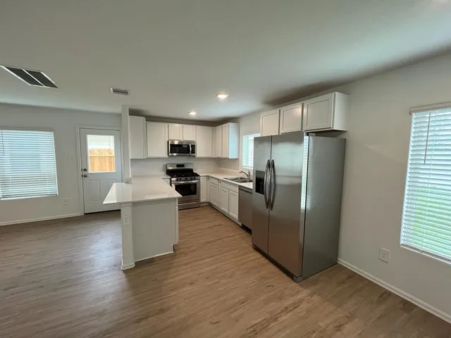 a kitchen with refrigerator and window