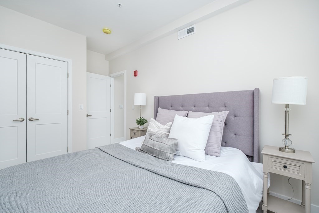 1540 North Shore Road, Unit 301 Revere, MA 02151 - Photo 7 of 14 a bedroom with a bed and a lamp