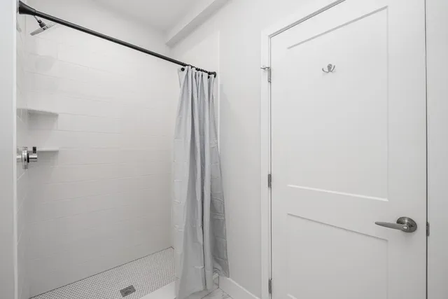 a bathroom with a shower and a glass shower door