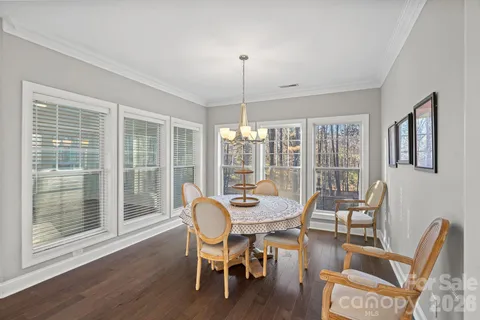 a dining room with furniture a chandelier and wooden floor