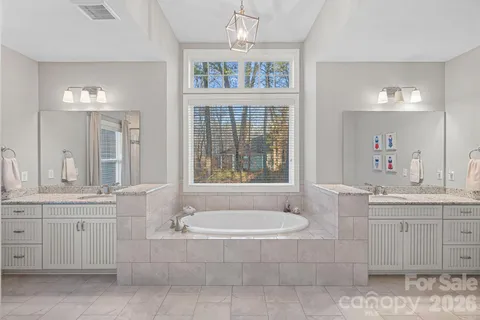 a bathroom with a tub a sink and mirror