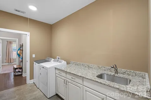 a utility room with a sink dryer and washer
